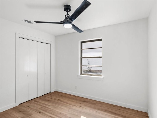 unfurnished bedroom with light hardwood / wood-style floors, ceiling fan, and a closet