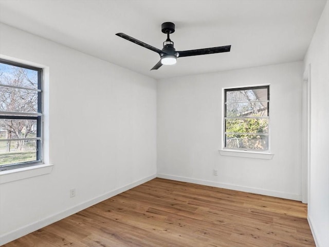 spare room featuring ceiling fan, a healthy amount of sunlight, and light wood-type flooring