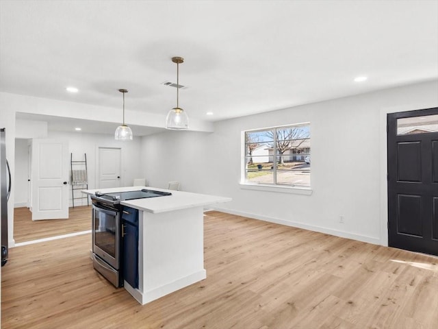 kitchen featuring pendant lighting, stainless steel electric stove, light hardwood / wood-style floors, and a kitchen island