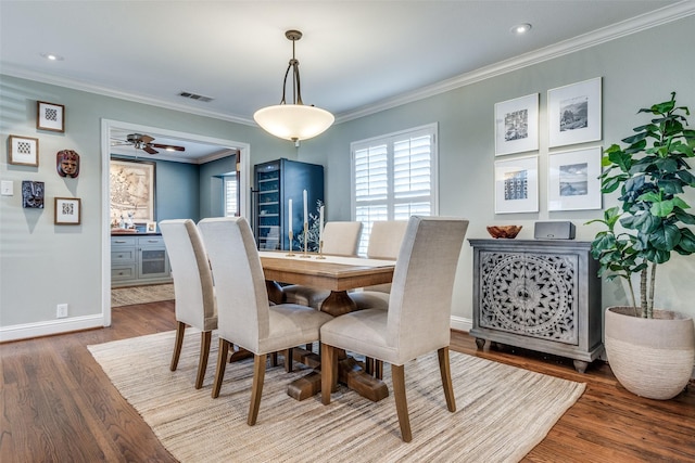 dining room featuring hardwood / wood-style flooring, ceiling fan, and ornamental molding