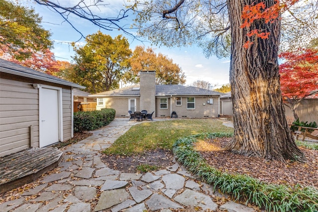 back of property featuring a yard and a patio