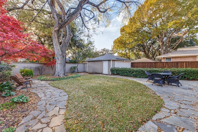 view of yard with a patio area, an outdoor structure, and a garage