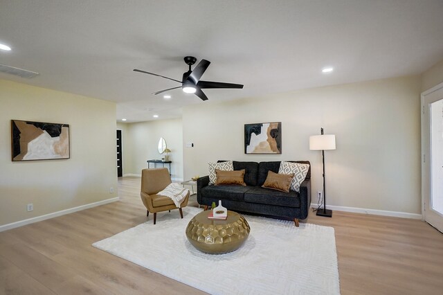 living room featuring ceiling fan and light hardwood / wood-style flooring