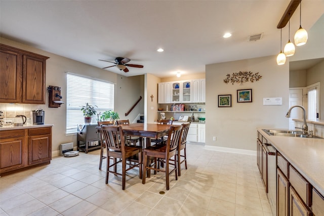 tiled dining room featuring ceiling fan and sink