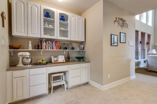 bar featuring white cabinetry and light tile patterned floors