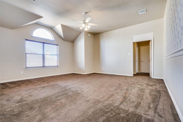 empty room with ceiling fan, carpet, and vaulted ceiling