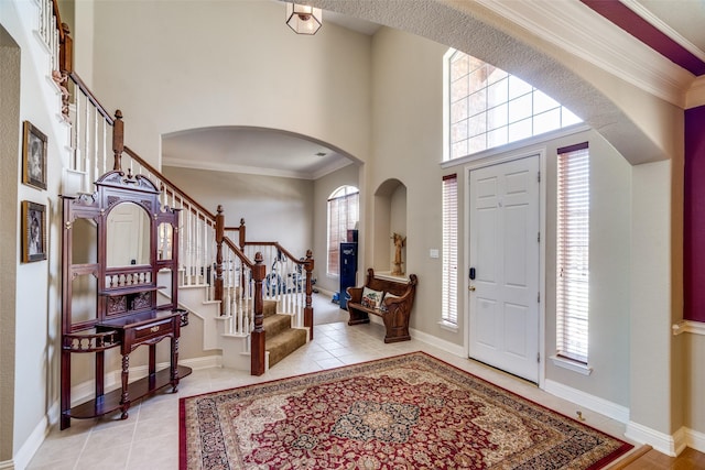 tiled entrance foyer with a towering ceiling and a wealth of natural light