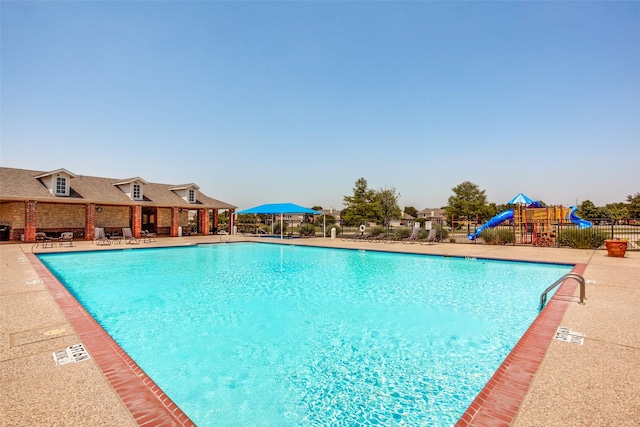 view of swimming pool with a patio and a water slide