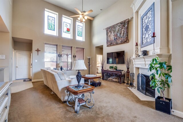 living room featuring carpet, ceiling fan, a towering ceiling, and a fireplace