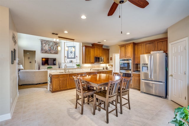 kitchen featuring kitchen peninsula, appliances with stainless steel finishes, ceiling fan, sink, and light tile patterned floors