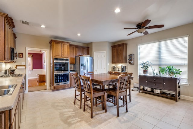 tiled dining space with ceiling fan