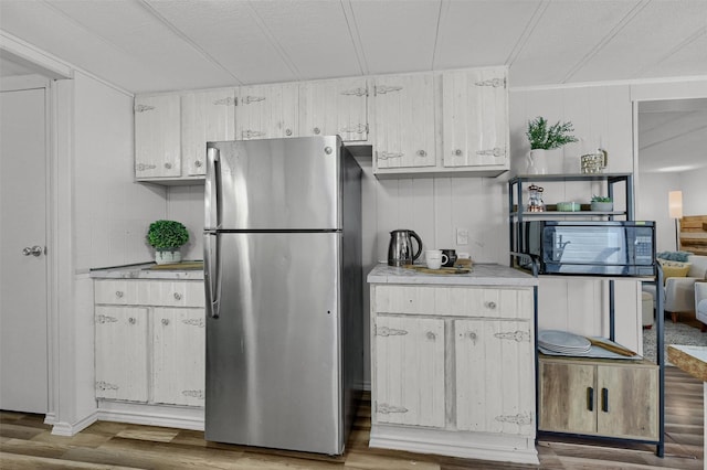 kitchen with stainless steel refrigerator, hardwood / wood-style floors, and a textured ceiling