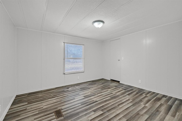 spare room with hardwood / wood-style flooring and a textured ceiling