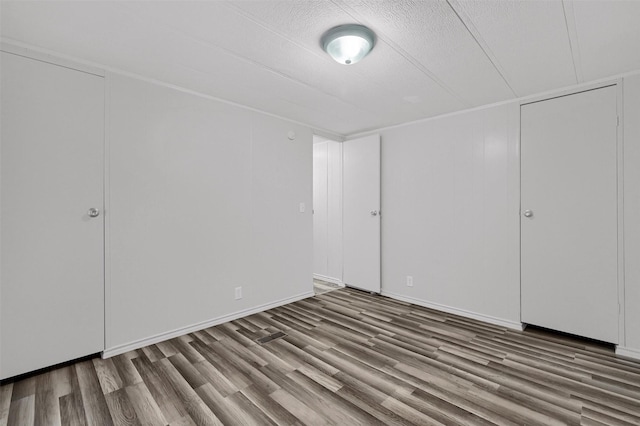 unfurnished bedroom with hardwood / wood-style flooring and a textured ceiling