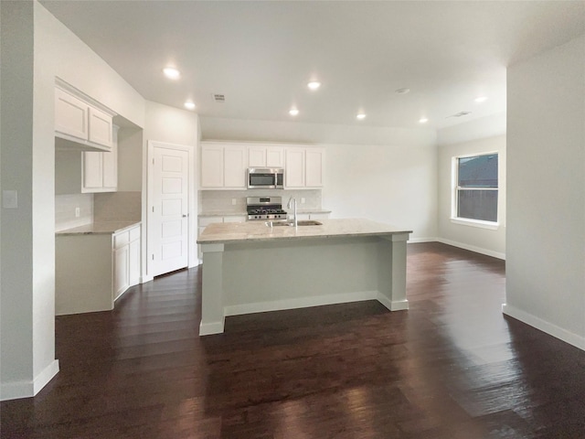 kitchen featuring a kitchen island with sink, dark wood-type flooring, sink, white cabinetry, and stainless steel appliances