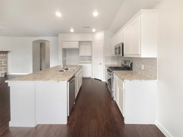 kitchen featuring white cabinetry, decorative backsplash, a kitchen island with sink, and stainless steel appliances