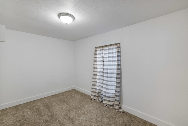 carpeted empty room with a textured ceiling