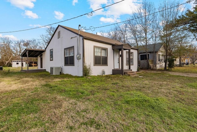 view of front of home with central AC and a front lawn