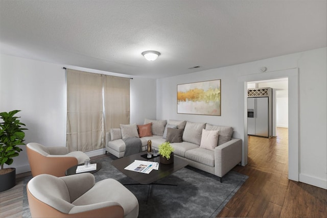 living room with a textured ceiling and dark hardwood / wood-style flooring