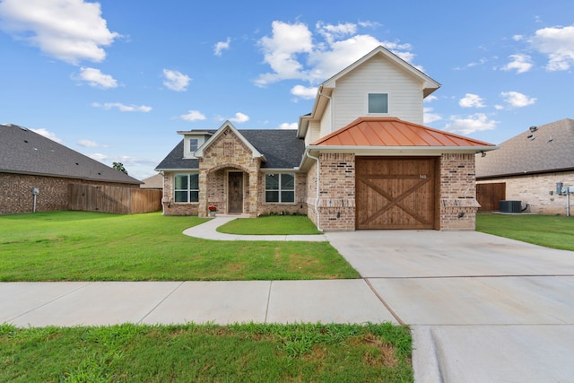 view of front of property with central AC unit, a front yard, and a garage