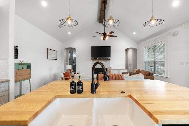 kitchen with butcher block countertops, sink, and pendant lighting