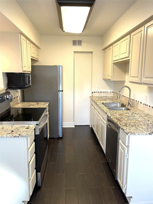 kitchen with white cabinets, light stone countertops, sink, and appliances with stainless steel finishes