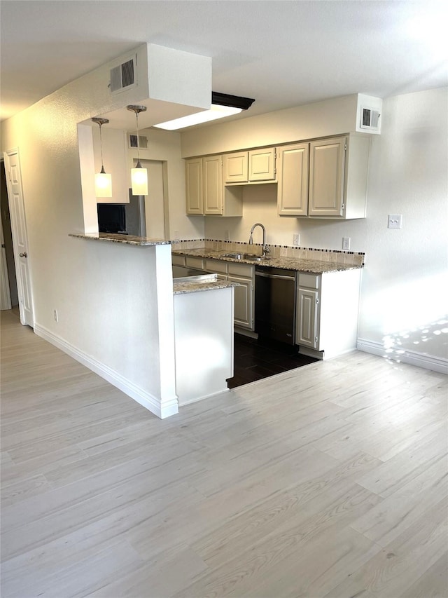 kitchen with sink, stainless steel dishwasher, kitchen peninsula, pendant lighting, and light hardwood / wood-style floors