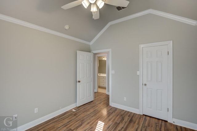 unfurnished bedroom with crown molding, dark wood-type flooring, ceiling fan, and vaulted ceiling