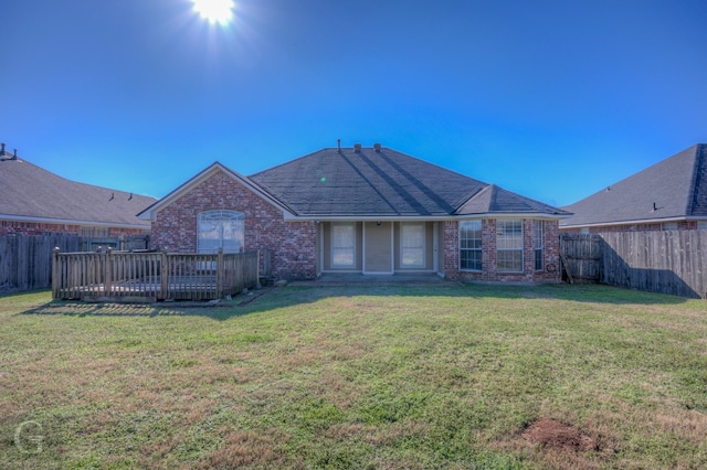 rear view of house featuring a yard and a deck