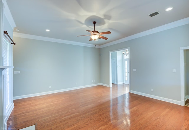 empty room featuring light wood-type flooring, ceiling fan with notable chandelier, and crown molding