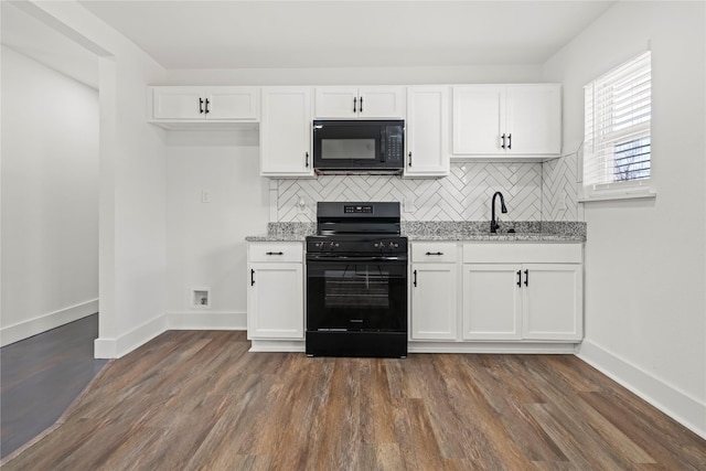 kitchen with decorative backsplash, white cabinetry, light stone countertops, and black appliances