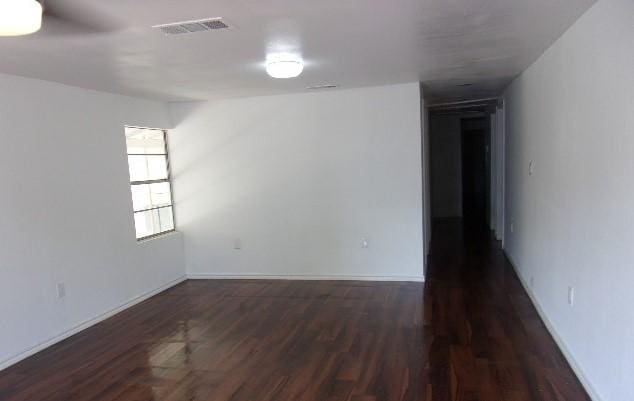 spare room with dark wood-type flooring