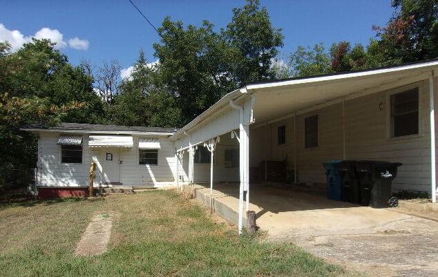 back of property with a carport