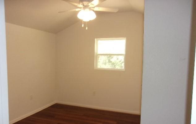 unfurnished room featuring ceiling fan, dark hardwood / wood-style flooring, and lofted ceiling