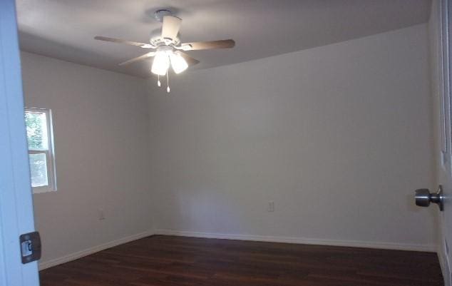 spare room with dark hardwood / wood-style flooring and ceiling fan