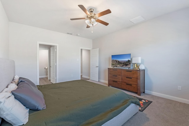 carpeted bedroom featuring ceiling fan and ensuite bathroom