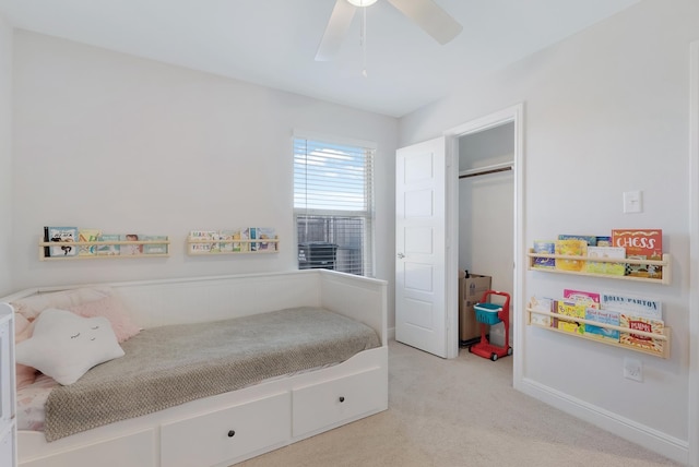 bedroom with ceiling fan, light colored carpet, and a closet