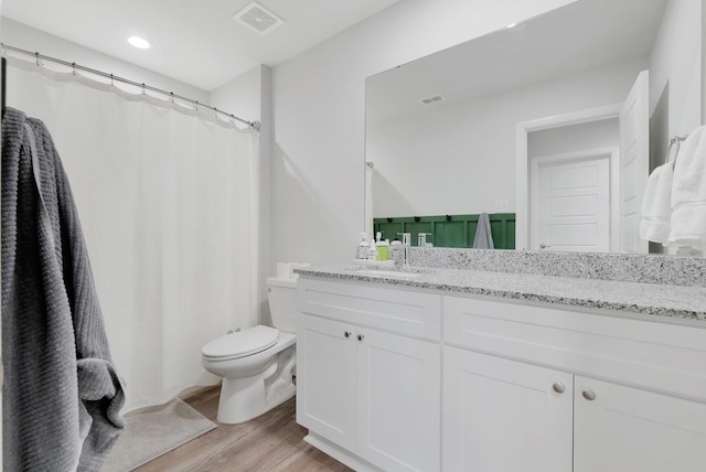 bathroom featuring toilet, hardwood / wood-style flooring, and vanity