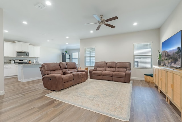 living room with ceiling fan and light hardwood / wood-style floors