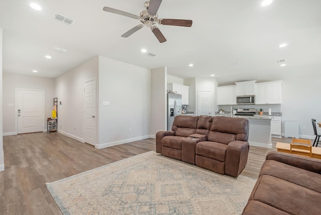 living room featuring ceiling fan and light wood-type flooring