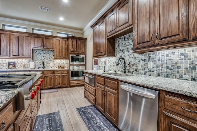 kitchen featuring light stone countertops, a kitchen island, stainless steel appliances, tasteful backsplash, and a raised ceiling