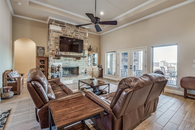 living room with crown molding, wood-type flooring, french doors, a raised ceiling, and ceiling fan