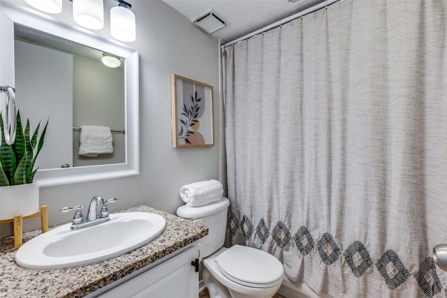 bathroom with walk in shower, vanity, and toilet