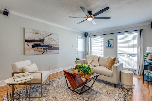 living room featuring a wealth of natural light, crown molding, and wood-type flooring