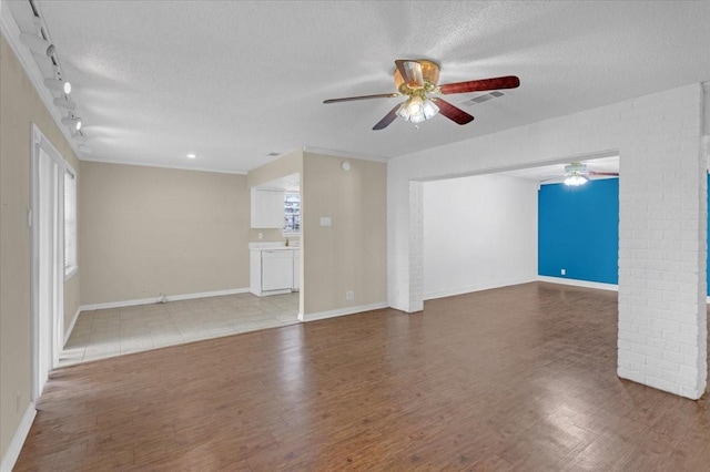 unfurnished living room featuring a textured ceiling, track lighting, hardwood / wood-style flooring, and ceiling fan