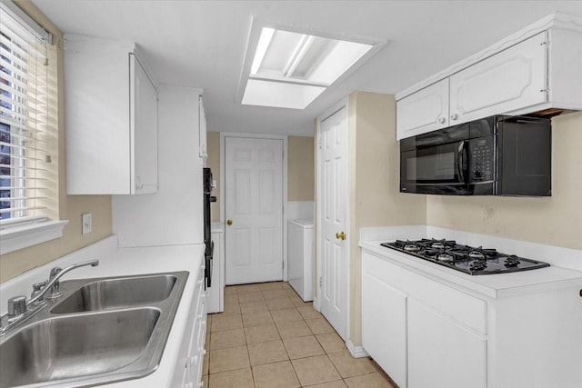 kitchen featuring white cabinets, sink, multiple ovens, light tile patterned floors, and gas cooktop