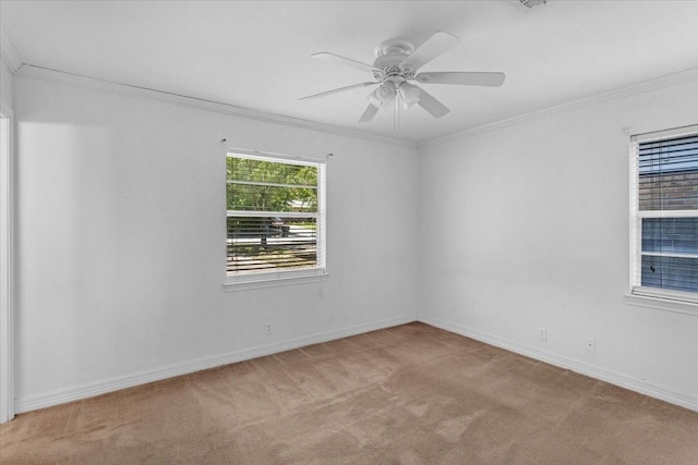 carpeted empty room featuring ceiling fan and crown molding