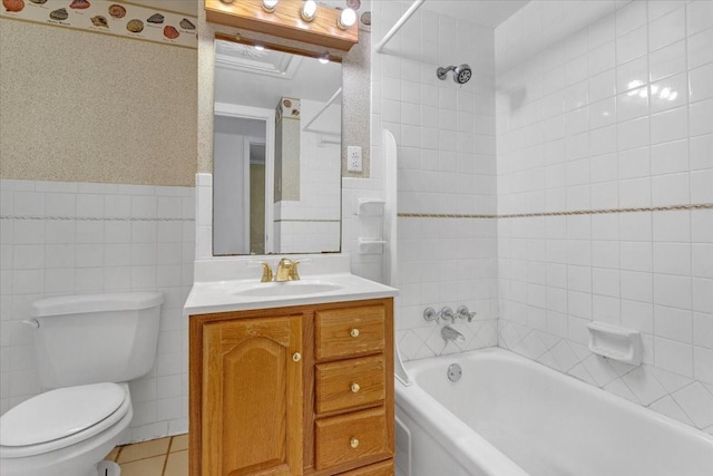 full bathroom with tile patterned floors, vanity, tiled shower / bath combo, tile walls, and toilet