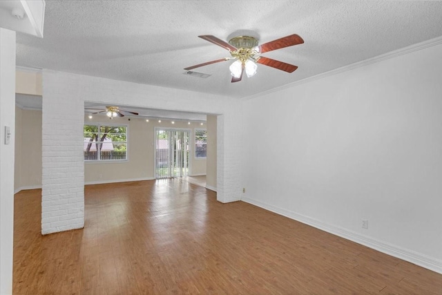 empty room with hardwood / wood-style floors, a textured ceiling, ceiling fan, and crown molding