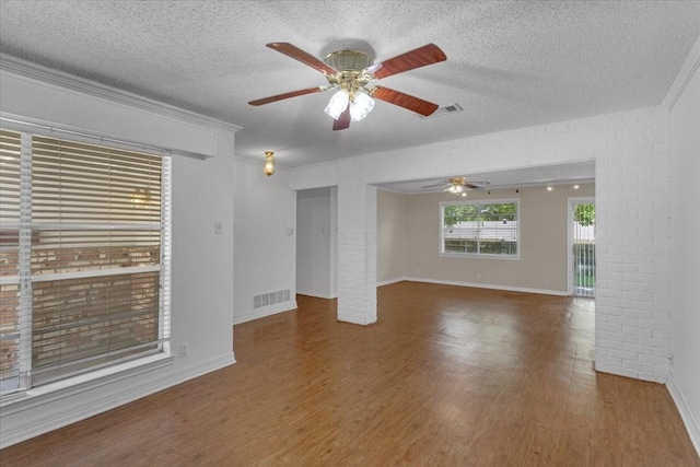 unfurnished living room with a textured ceiling, ceiling fan, and dark wood-type flooring